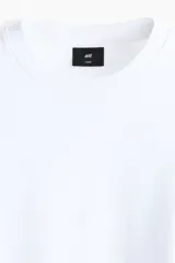 Remera blanca boxy de punto liviano de algodón, con hombros caídos, cuello redondo acanalado y corte oversized.