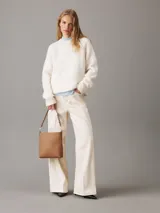 Cartera tipo saco color tostado de cuero sintético granulado, con correa de hombro ajustable de cuero sintético y correa bandolera ajustable de jacquard con logo.