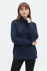 Polera de algodón azul marino con cuello alto vuelto, manga larga y diseño holgado de tejido texturizado.