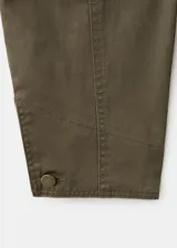 Chaqueta verde militar corta con cuello camisero de pana marrón oscuro, cierre frontal de botones, bolsillos aplicados en el pecho y diseño holgado.