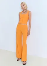 Top de algodón color naranja, sin mangas, con tirantes anchos, escote recto y cierre frontal con botones.