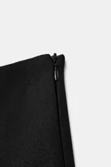 Falda pantalón de tiro medio color negro, con detalle de abertura en el delantero y cierre lateral con cremallera oculta.