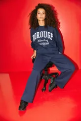 Buzo azul marino con estampado frontal blanco que dice "BOROUGH Market SOUTHWARK London". Tiene cuello redondo, mangas abullonadas con puños acanalados y ruedo acanalado.