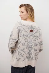 Buzo de tejido de punto en color marrón con un patrón ornamental floral en color celeste. Presenta cuello redondo, mangas largas y un corte holgado.