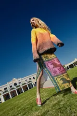 Sweater tejido multicolor con degradé de amarillo a naranja y marrón, con cuello redondo y terminaciones en punto elástico negro.