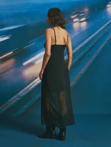 Vestido largo negro con escote en V, tirantes finos y falda transparente.