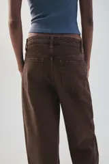 Jeans de tiro medio color marrón con diseño de volumen crop, silueta holgada en las piernas y cinco bolsillos tradicionales. Cierre frontal con cremallera y botón metálico.