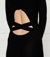 Vestido largo negro ajustado de punto acanalado, con cuello redondo, mangas largas y cinta entrecruzada en la cintura.