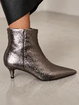 Bota corta de cuero con punta fina y taco fino de 5 cm, diseño minimalista y elegante.