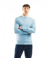 Buzo de punto color verde claro, con cuello redondo y mangas largas.