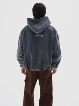 Hoodie de denim color tostado con lavado soft, corte vertical en la parte delantera, bolsillo canguro, puños y dobladillo elásticos. Presenta un bordado de estrella rosa en el pecho izquierdo y el texto "LES ENFANTS 1984" en el pecho derecho.