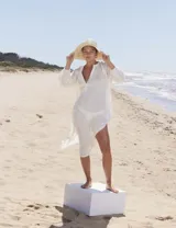 Vestido túnica blanco de corte recto, con escote en V y mangas largas.