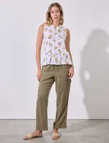 Blusa sin mangas de algodón estampado con flores amarillas, cuello a la base, escote en V y entrelazado. Terminación de ruedo con frunce.