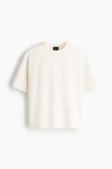 Remera de algodón pesado color blanco con cuello redondo acanalado, hombros caídos y corte holgado de silueta boxy.