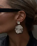 Caravanas colgantes de diseño circular con acabado plisado y brillante, compuestas por una pieza superior pequeña y una pieza inferior grande de forma ondulada.