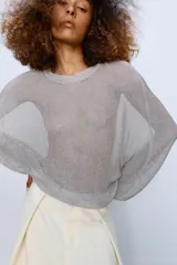 Jersey de punto con acabado metalizado, cuello redondo y manga larga con sisa ancha de diseño holgado.