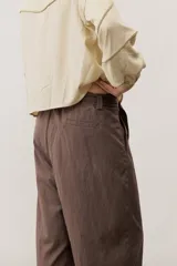 Pantalón de corte ancho y holgado, de color negro, con diseño estructurado y cinturón ajustable integrado en la cintura.