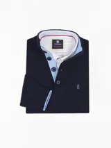 Buzo azul marino de algodón con cuello doble abotonado y ribete rojo en cuello, puños y ruedo.