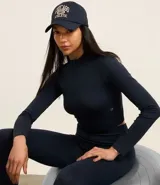 Remera deportiva negra de poliamida seamless con cuello alto, cierre frontal parcial y mangas largas.