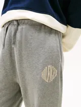 Pantalón de jogging gris de felpa, de corte relajado, con cintura elástica, bolsillos laterales y logo bordado en la pierna.