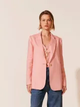 Blazer rosa de lino, con solapas de muesca, cierre frontal con un botón dorado y corte entallado.
