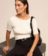 Blusa negra de viscosa con cuello redondo, mangas cortas y textura acanalada. Presenta un recorte oval en la espalda.