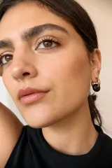 Aros dorados con dije circular de piedra natural negra.