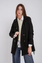 Trench de gabardina color negro, con diseño de doble botonadura, solapas clásicas y puños ajustables con trabillas.