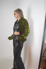 Campera verde aceituna de terciopelo con cierre frontal, cuello alto y puños elásticos.