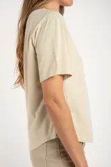 Remera de manga corta y cuello redondo, color arena, con calce al cuerpo.