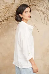 Campera color beige de lino, con cuello mao, mangas 3/4 con botón para sujetar, cierre frontal con botones y ajuste con cordón en la cintura.