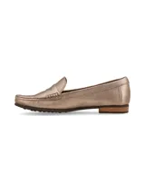 Mocasín de cuero color dorado, de corte clásico y elegante, con líneas simples y suela de goma.