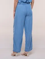Pantalón fluido de estilo pull-on y silueta amplia confeccionado en lyocell de tacto sedoso, color azul. Cuenta con cintura totalmente elastizada con cordón ajustable, amplios bolsillos delanteros aplicados tipo parche y pierna de corte ancho y recto terminada con dobladillo deshilachado.