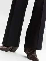 Pantalón wide leg de tiro alto negro, con pinzas y costuras frontales marcadas.