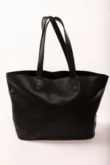 Bolso tote negro de cuero vacuno con doble asa de hombro. Incluye un bolsillo separador extraíble.