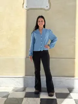 Camisa de jean celeste con cuello redondo, cierre frontal con botones y mangas largas abullonadas con puños ajustados.