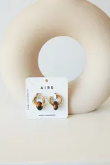 Aros dorados con dije circular de piedra natural negra.