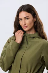 Campera liviana con capucha, de corte clásico, color beige, con bolsillos laterales con solapa y cierre frontal.