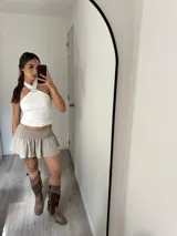 Minifalda de tiro bajo color beige, con cintura elástica fruncida y diseño acampanado con volados.