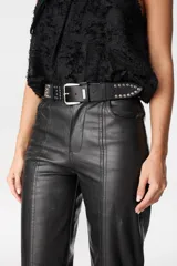 Cinturón de cuero negro con hebilla metálica plateada y detalle de tachas metálicas circulares a lo largo de la tira.