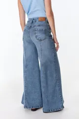 Pantalón de jean celeste con corte acampanado, tiro alto y costuras verticales al frente.
