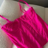 Corset fucsia de encaje con copas con aro y tirantes finos regulables.