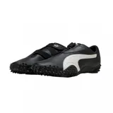 Championes Puma modelo Mostro Perforated, de diseño bajo con exterior de cuero perforado en color blanco y detalles en negro. Presenta una suela distintiva con relieve de tachones y cierre de velcro en el empeine.