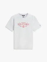 Remera de manga corta gris melange con cuello redondo, confeccionada en algodón regenerativo. Presenta un logo gráfico bordado en rojo en el pecho y el detalle de la bandera de la marca bordada en la manga.