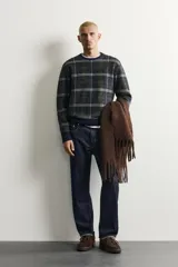 Jersey de punto con lana, de corte relajado, cuello redondo y manga larga. Presenta un diseño de cuadros en tonos oscuros con acabados en rib en cuello, puños y bajo.