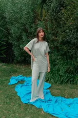 Conjunto de dos piezas de tejido rib con patrón de rayas horizontales blancas y verde militar, compuesto por una remera de manga corta con abertura frontal y un pantalón de corte recto y holgado.