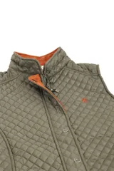 Chaleco beige capitoneado con cierre frontal y cuello de pana marrón.