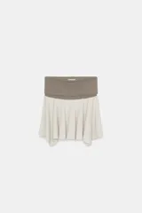 Falda mini de tiro bajo con cintura elástica ancha en color gris y falda acampanada en color beige con bajo asimétrico.