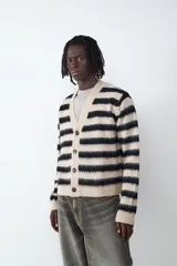 Cardigan de punto con diseño a rayas horizontales en tonos beige y negro, cuello en pico y cierre frontal con botones.