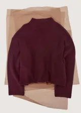 Sweater de punto color bordó, con cuello alto, mangas largas y diseño holgado.